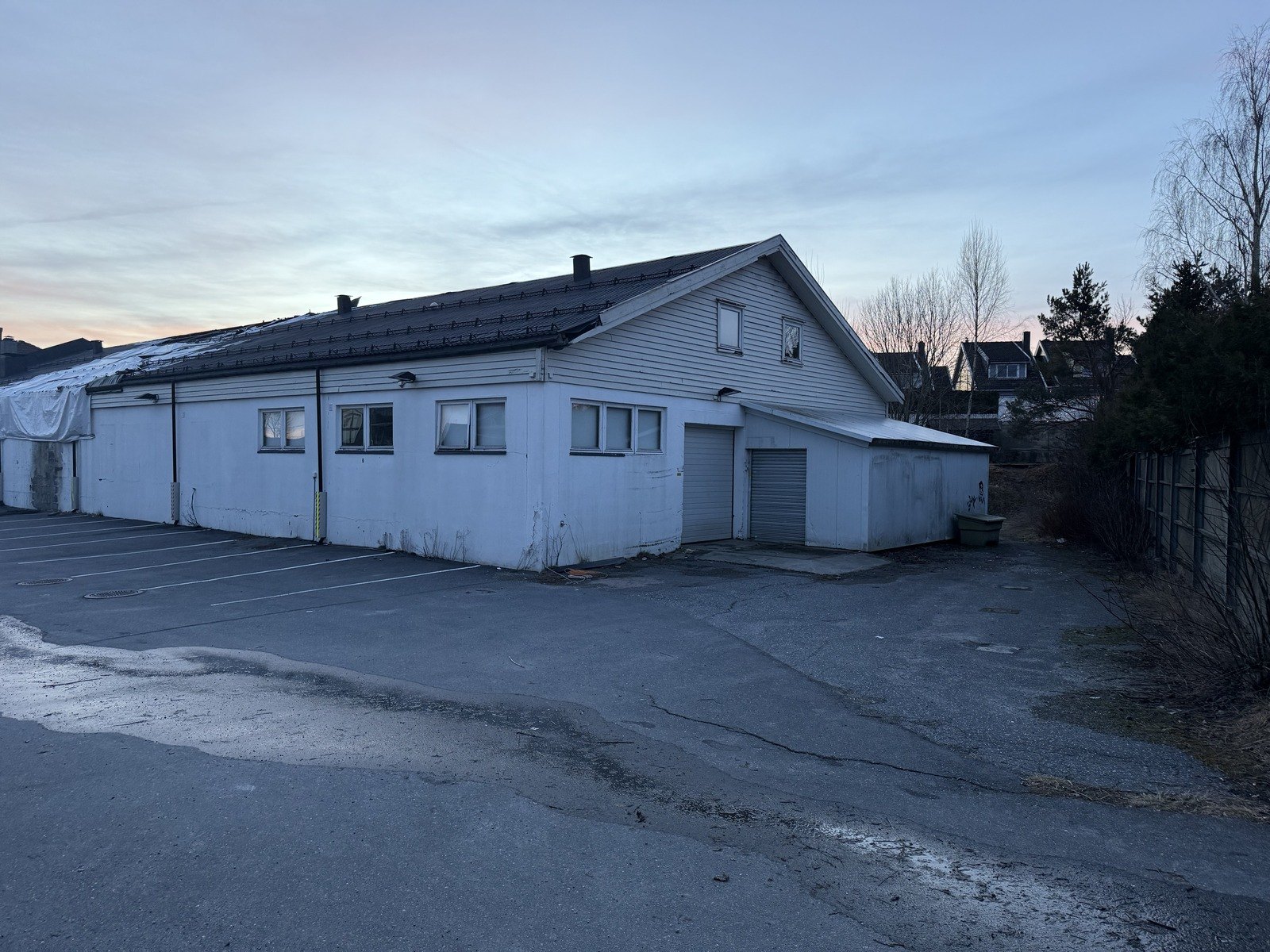 I dag: Fra Nygårdsveien mot sørvest: hus B, rampen til P-kjelleren med pergola og hagen bak.